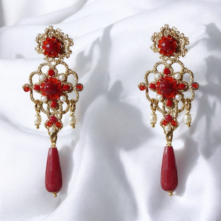 A pair of elegant red and gold earrings, showcasing a vibrant design that adds a touch of sophistication.