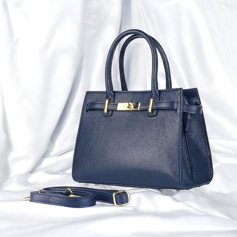 A blue leather handbag featuring elegant gold hardware, showcasing a stylish and sophisticated design.