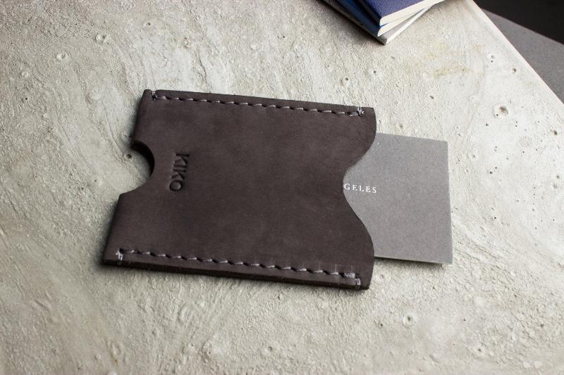 A wallet with a card holder resting on top, showcasing a sleek and organized design for easy access to cards.