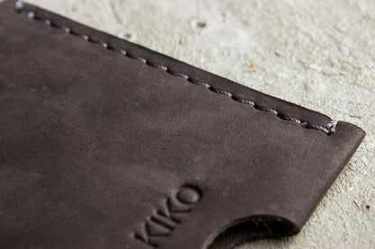 A wallet with a card holder resting on top, showcasing a sleek and organized design for easy access to cards.