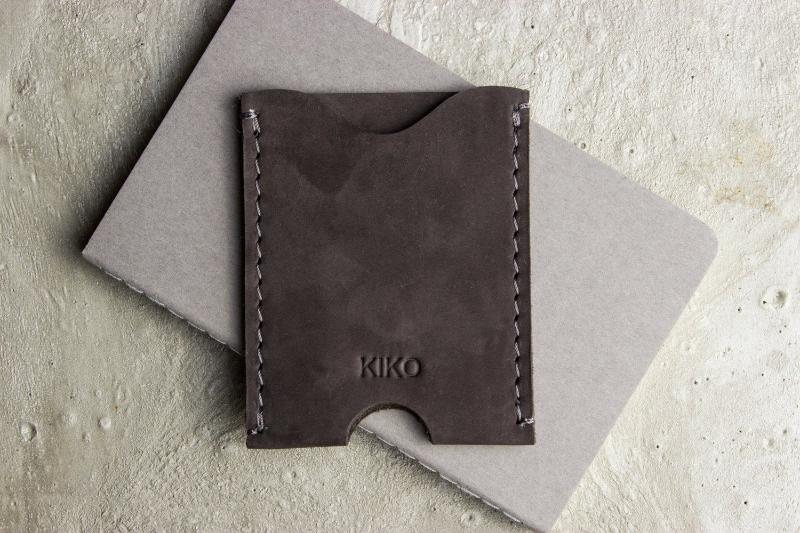 A wallet with a card holder resting on top, showcasing a sleek and organized design for easy access to cards.