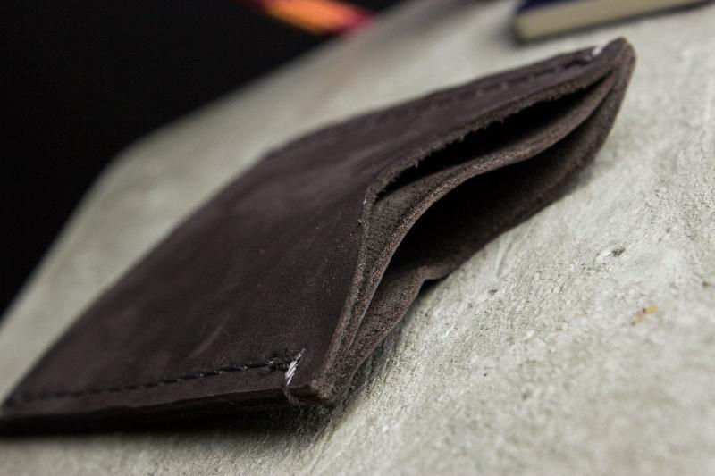 A wallet with a card holder resting on top, showcasing a sleek and organized design for easy access to cards.