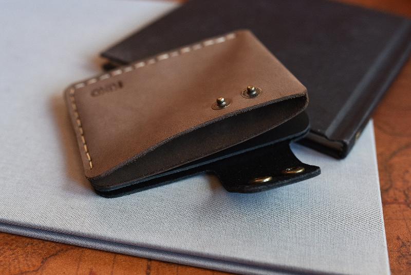 A sleek leather wallet topped with a compact book, highlighting a chic and organized lifestyle.