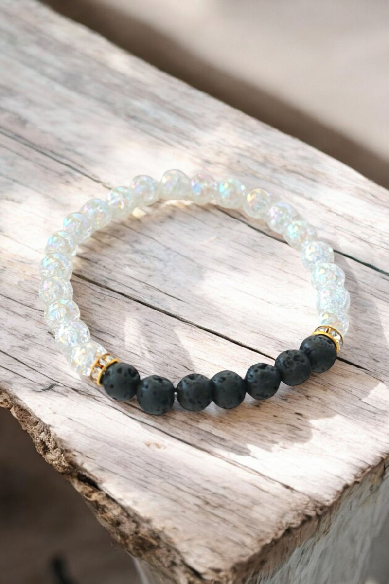 Black and white bracelet adorned with gold beads, showcasing a stylish and elegant design.

