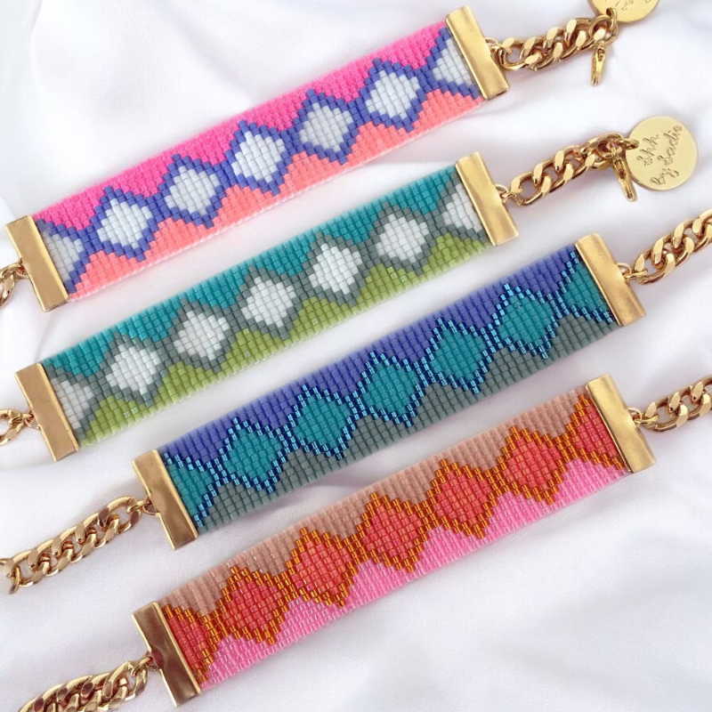 Three beaded bracelets in various colors, each adorned with elegant gold chains, displayed together.