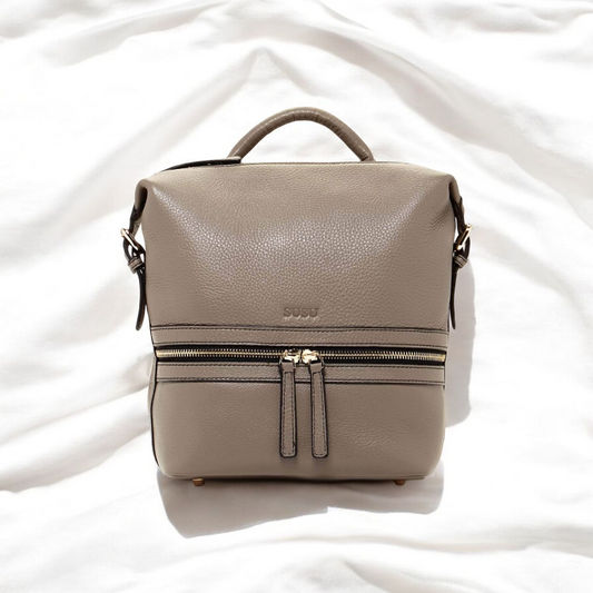 A small leather backpack featuring two zippers, showcasing a sleek and stylish design suitable for everyday use.
