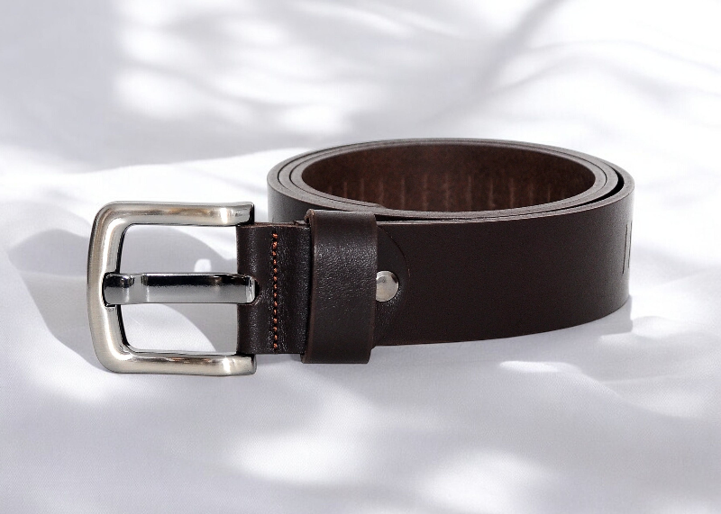 A brown leather belt featuring a polished silver buckle, showcasing a classic and elegant design.