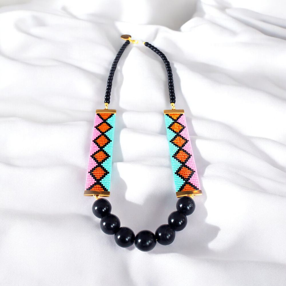 A vibrant necklace featuring an array of colorful beads interspersed with elegant black beads.