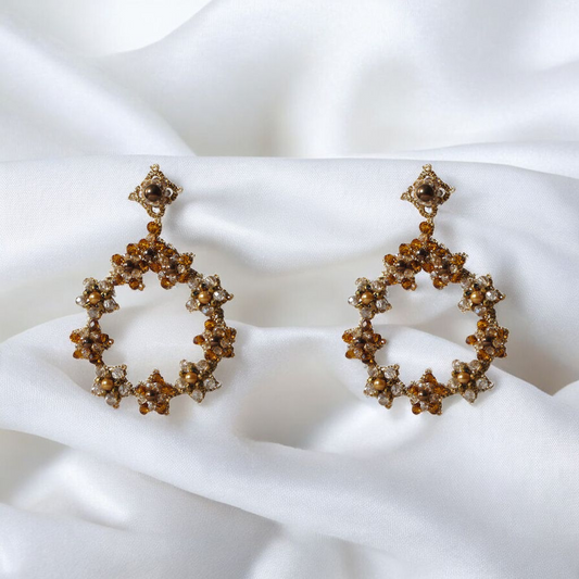 Gold and white earrings elegantly displayed, showcasing their intricate design and luxurious appeal.