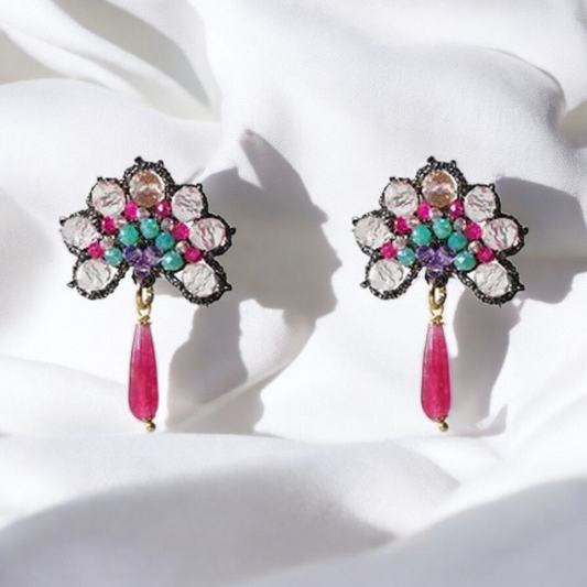 A pair of earrings featuring vibrant, colorful stones set in an elegant design.