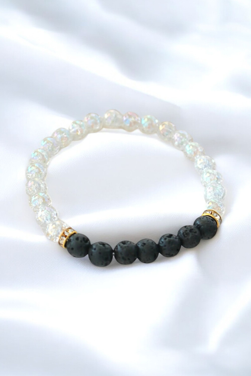 Black and white bracelet adorned with gold beads, showcasing a stylish and elegant design.

