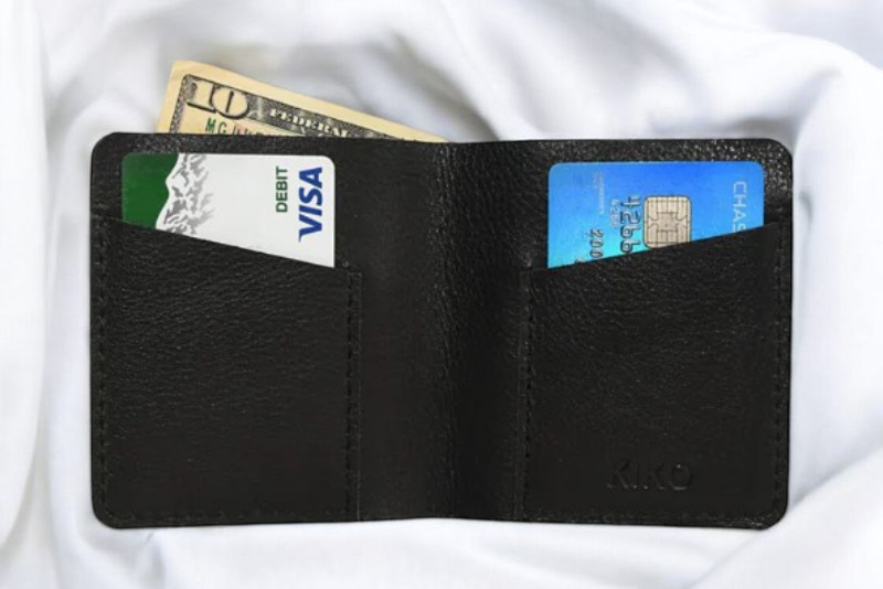 A sleek black leather wallet resting on a detailed map, perfect for travel planning and adventures.