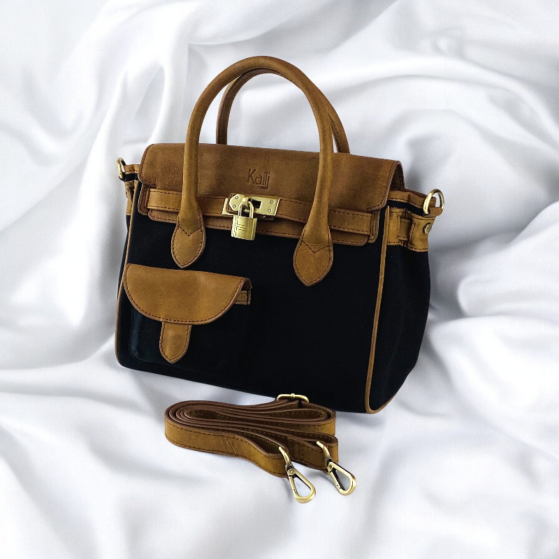 A sophisticated black and tan handbag featuring a stylish strap, perfect for elevating any ensemble with elegance.