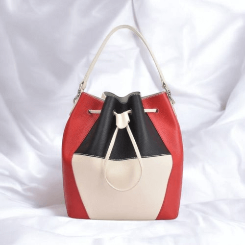 A stylish red and black bucket bag featuring a contrasting white handle, perfect for any casual or chic outfit.