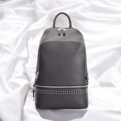 A black backpack featuring studded detailing on the front, showcasing a stylish and edgy design.