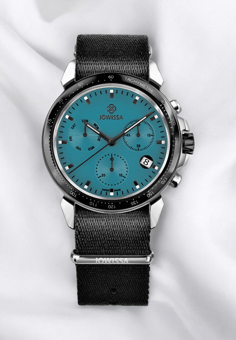 A stylish watch featuring a blue dial, elegantly displayed on a soft white cloth background.