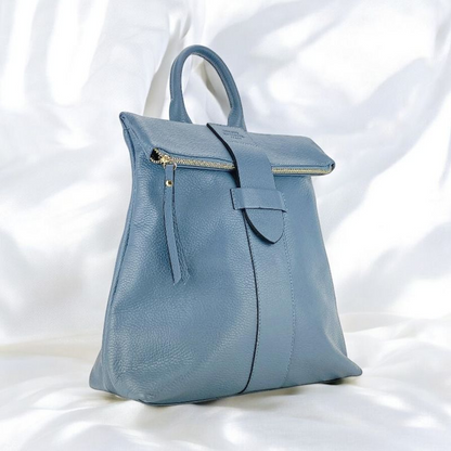 A blue leather backpack featuring a front zipper, showcasing a stylish and functional design.
