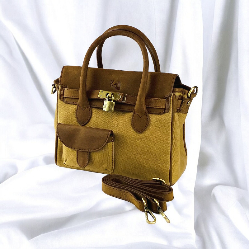 A tan and brown handbag featuring a stylish strap, perfect for everyday use and versatile fashion.