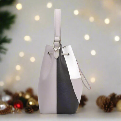 A stylish white and grey bucket bag featuring a convenient strap for easy carrying.