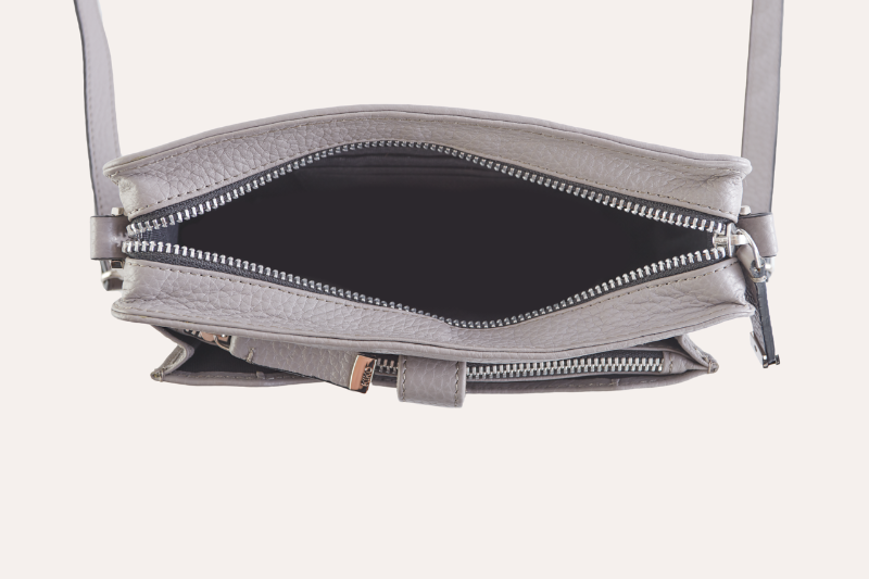  A sleek grey leather crossbody bag, compact and trendy, ideal for carrying essentials while on the go.
