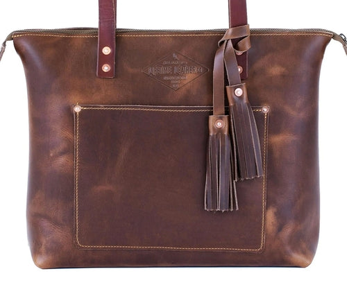 Elegant brown leather tote bag featuring a chic tassel on the handle, perfect for sophisticated outings.