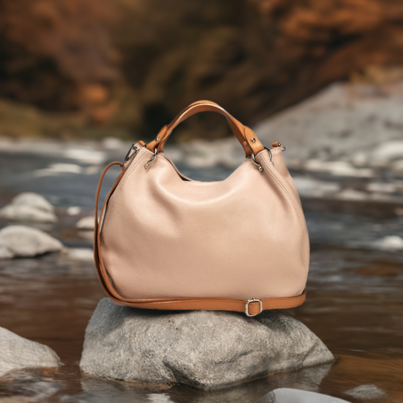 A sophisticated cipria/cognac leather bag featuring elegant tan handles, perfect for a touch of luxury in any ensemble.