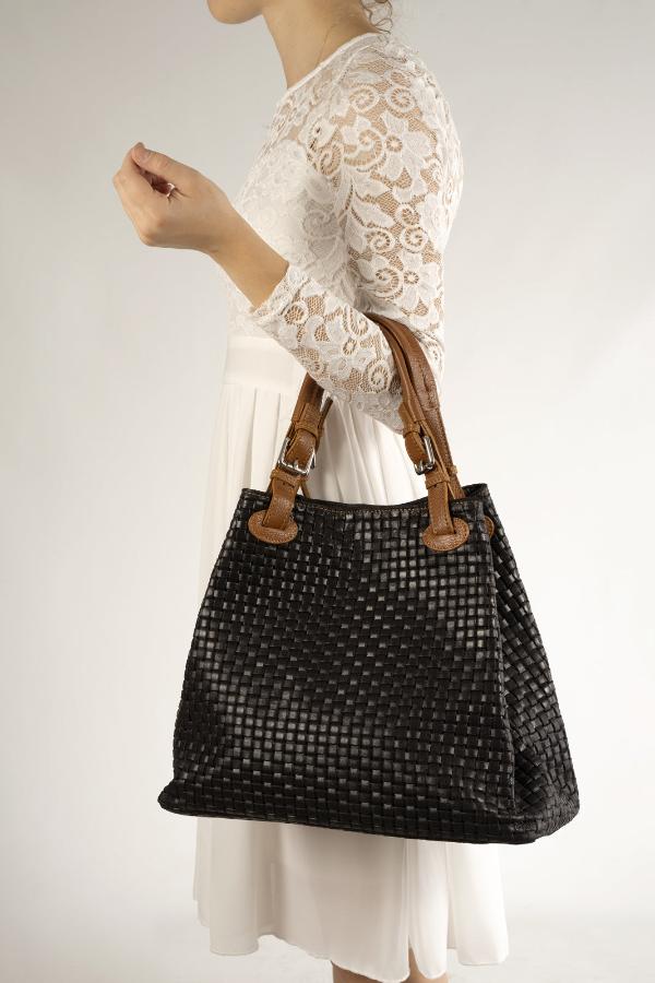 woman with white dress carry a black chic woven leather handbag