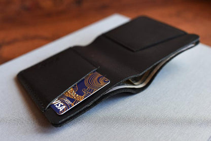 A sleek black leather wallet displaying two credit cards peeking out from its interior.