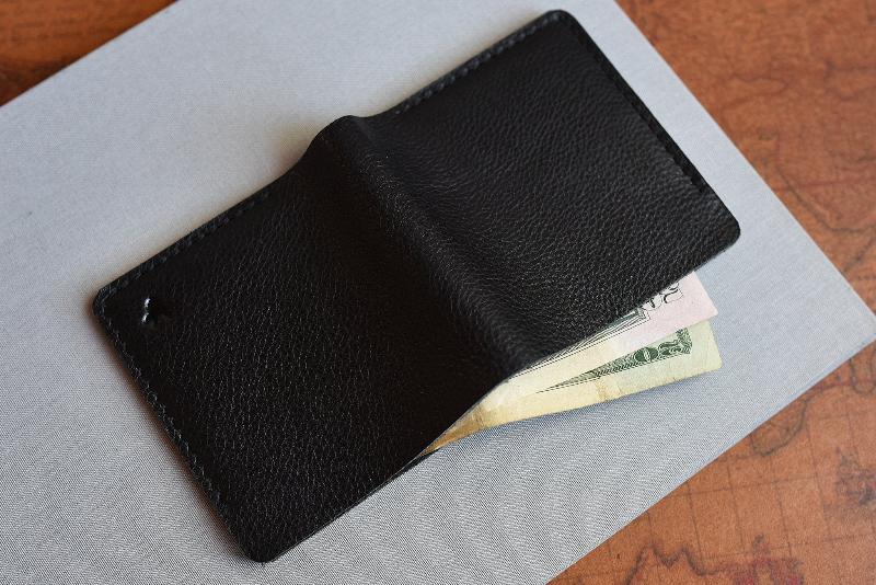 A sleek black leather wallet displaying two credit cards peeking out from its interior.