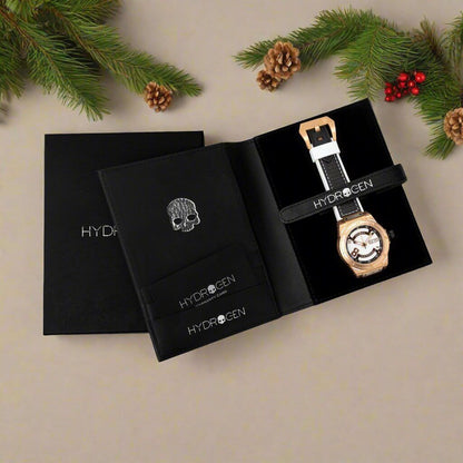 A watch placed beside a black box on a table, showcasing a stylish arrangement of accessories.