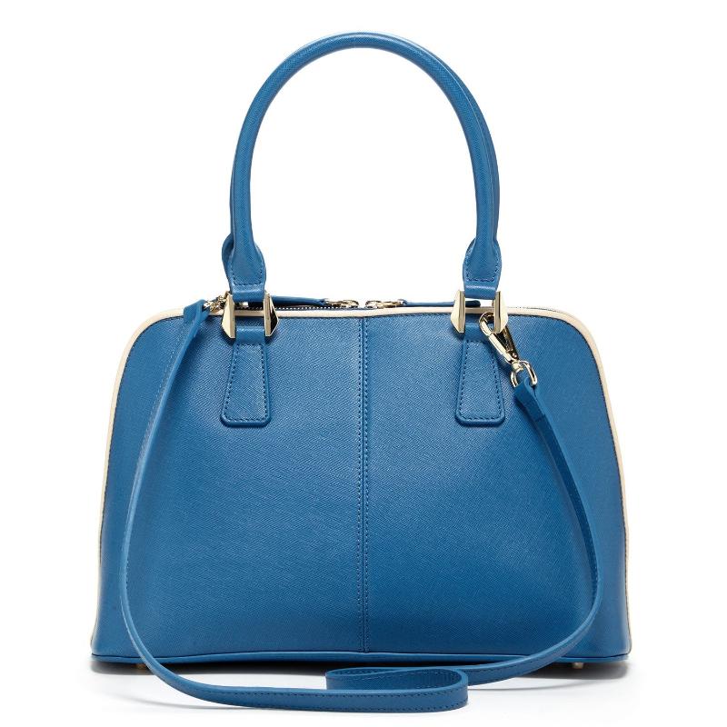 A chic blue handbag elegantly rests on a pristine white cloth, showcasing its vibrant hue against the soft backdrop.