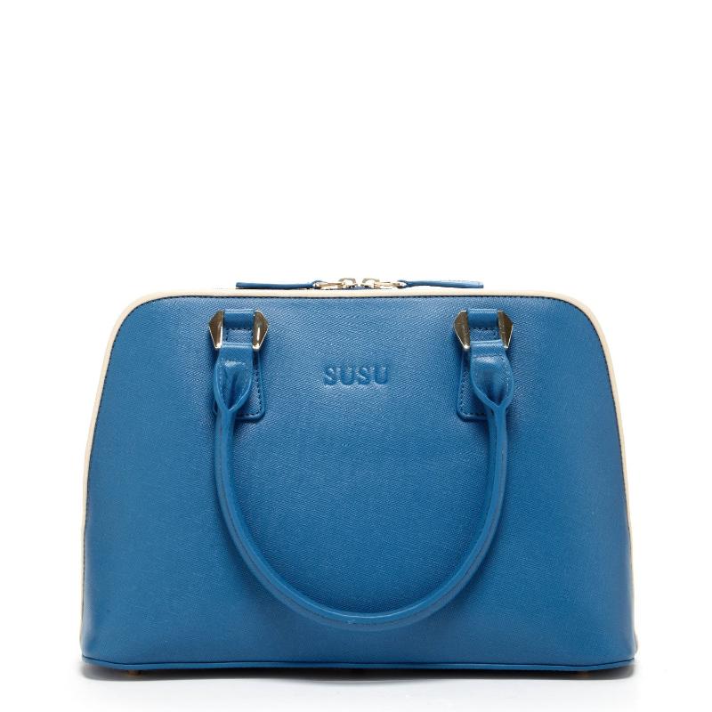 A chic blue handbag elegantly rests on a pristine white cloth, showcasing its vibrant hue against the soft backdrop.