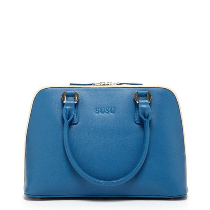 A chic blue handbag elegantly rests on a pristine white cloth, showcasing its vibrant hue against the soft backdrop.