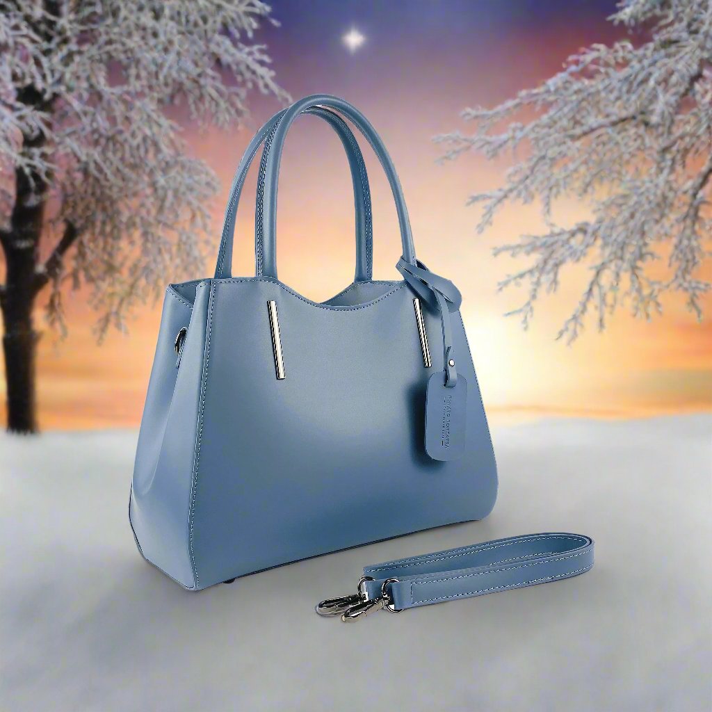 A blue leather handbag featuring a tag attached to it, showcasing its elegant design and craftsmanship.