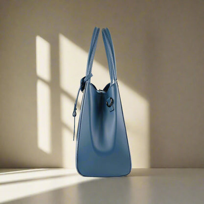 A blue leather handbag featuring a tag attached to it, showcasing its elegant design and craftsmanship.