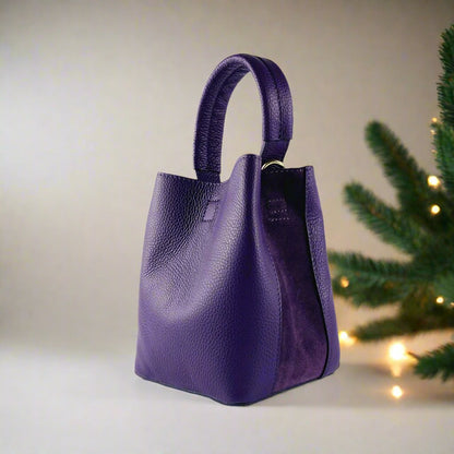 Elegant purple leather handbag featuring a chic strap, perfect for adding a touch of luxury to any ensemble.