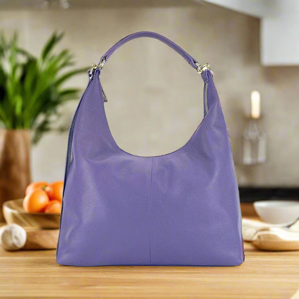 A luxurious purple leather hobo bag featuring a sleek zipper closure, exuding elegance and style.