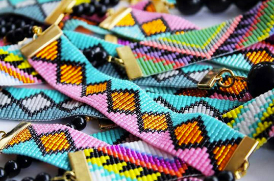 Vibrant close-up of an array of exquisite beaded bracelets, showcasing a kaleidoscope of colors and intricate designs.