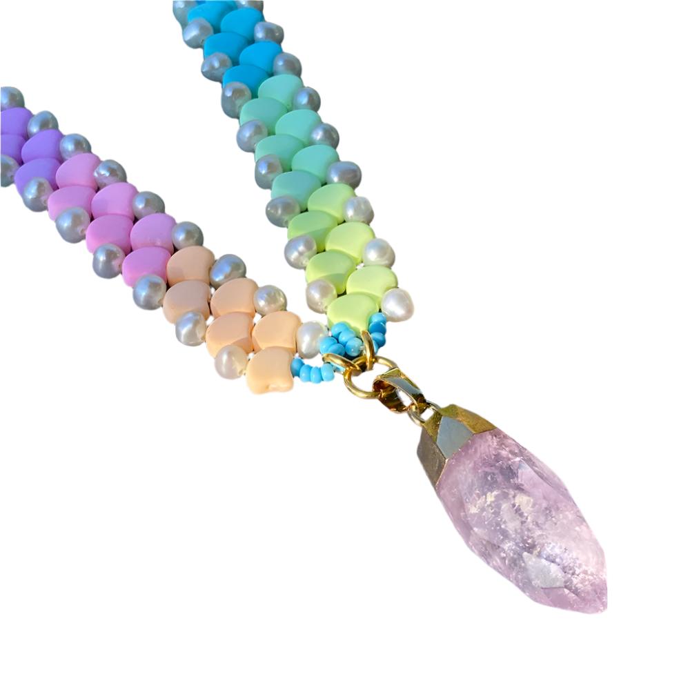 A vibrant rainbow-colored necklace featuring a striking crystal point at its center.