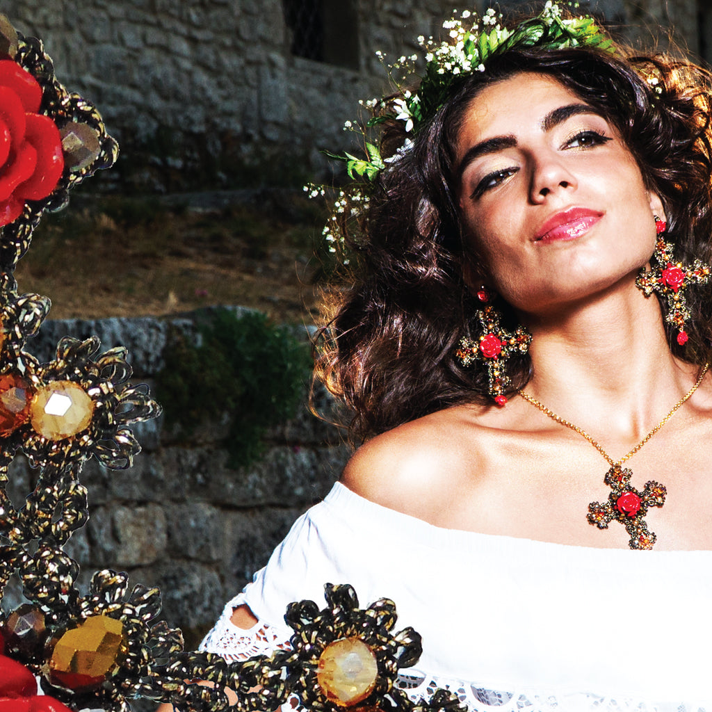 A woman in a flowing white dress highlights her beautiful earrings, creating a striking and elegant appearance.