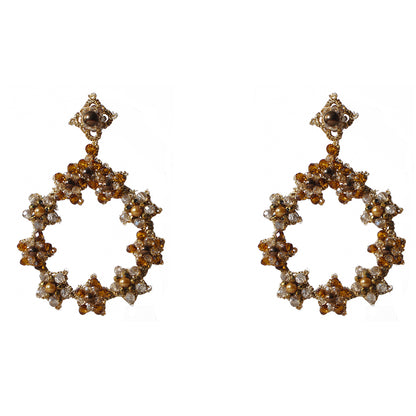 Gold and white earrings elegantly displayed, showcasing their intricate design and luxurious appeal.