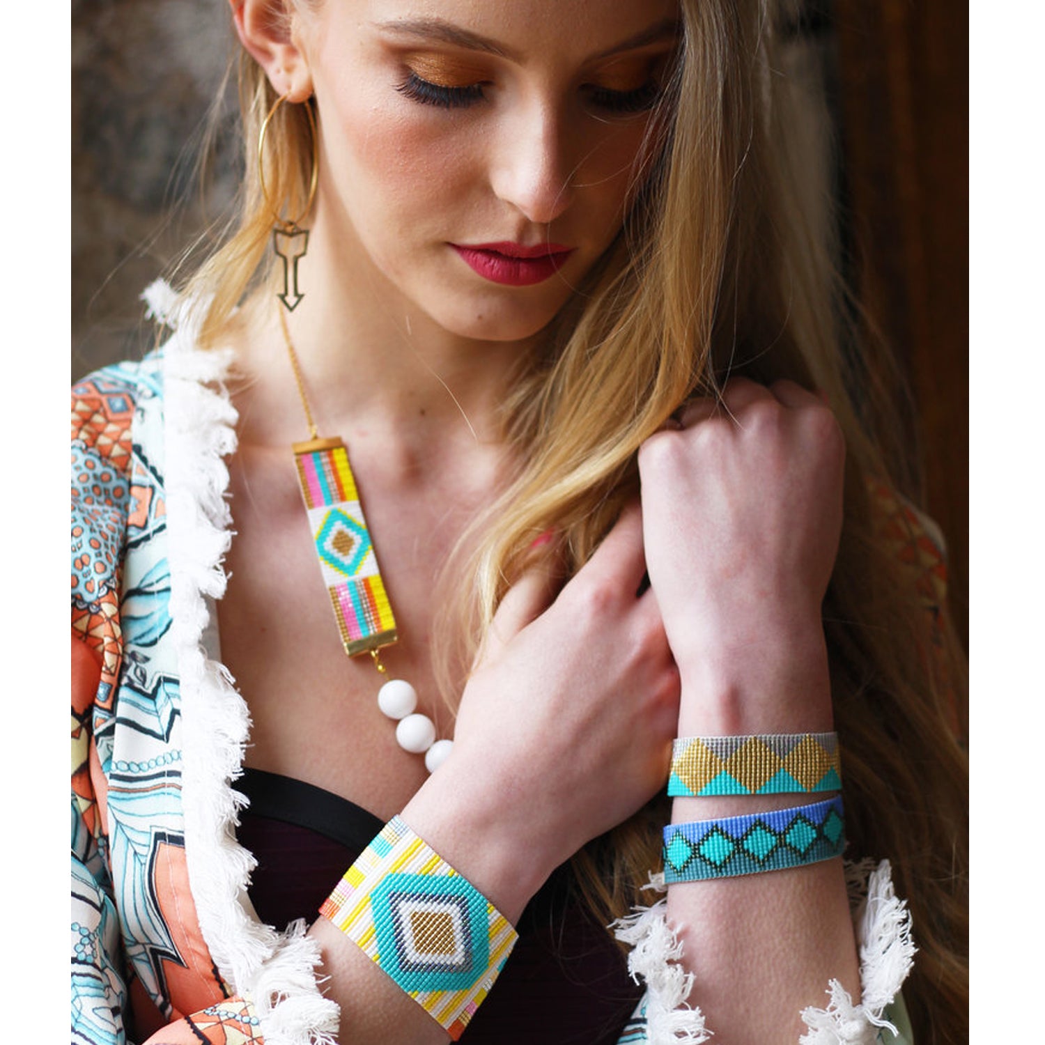 Three vibrant bracelets adorned with gold and silver charms, showcasing a blend of colors and intricate designs.