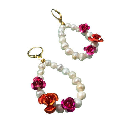 Elegant earrings featuring white pearls adorned with vibrant red flowers, perfect for adding a touch of sophistication.