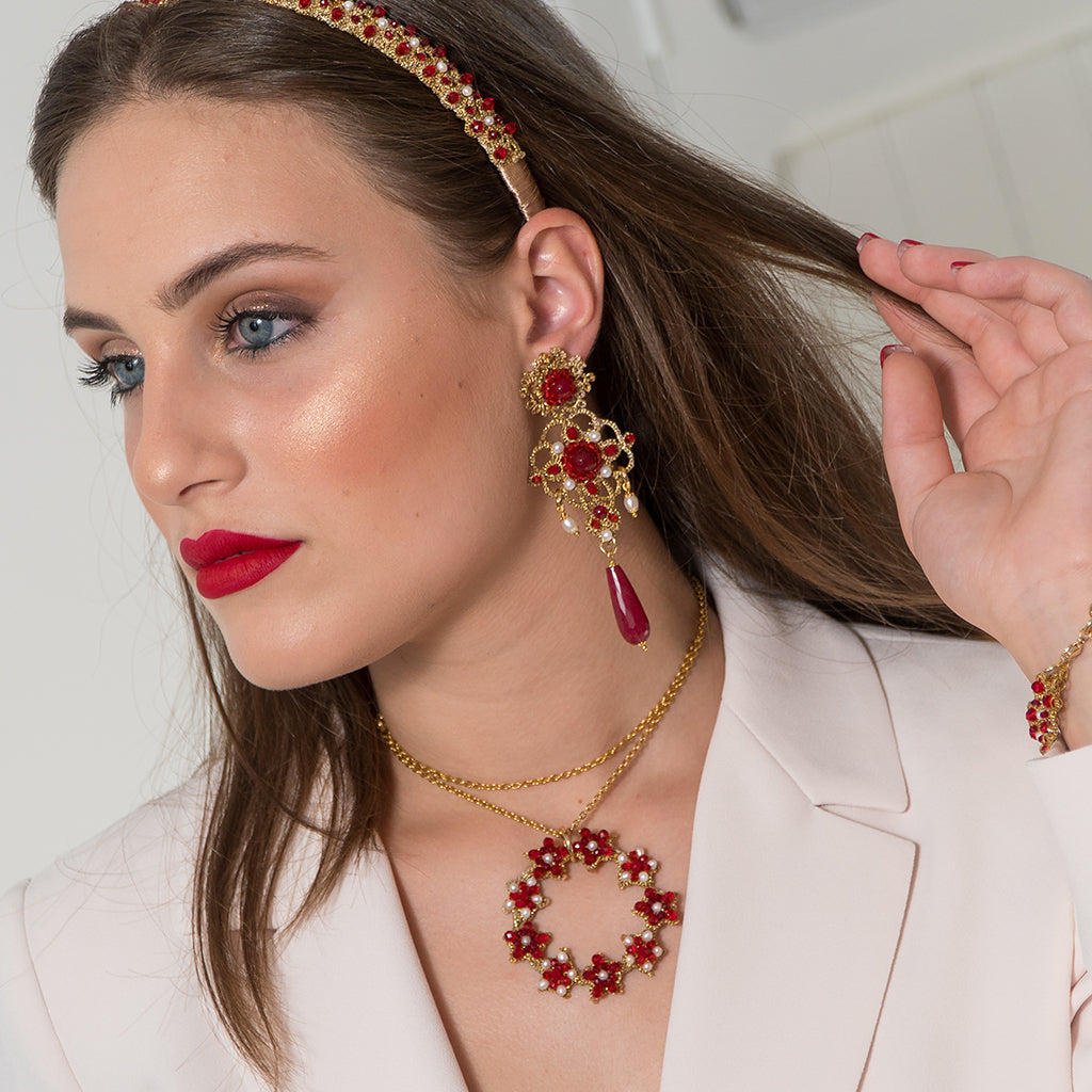 A pair of elegant red and gold earrings, showcasing a striking design and vibrant colors.