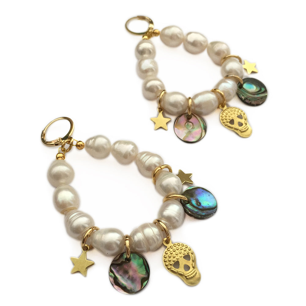  This earrings feature creamy freshwater pearls, beautifully complemented by glinting gold and shimmering shell charms. 