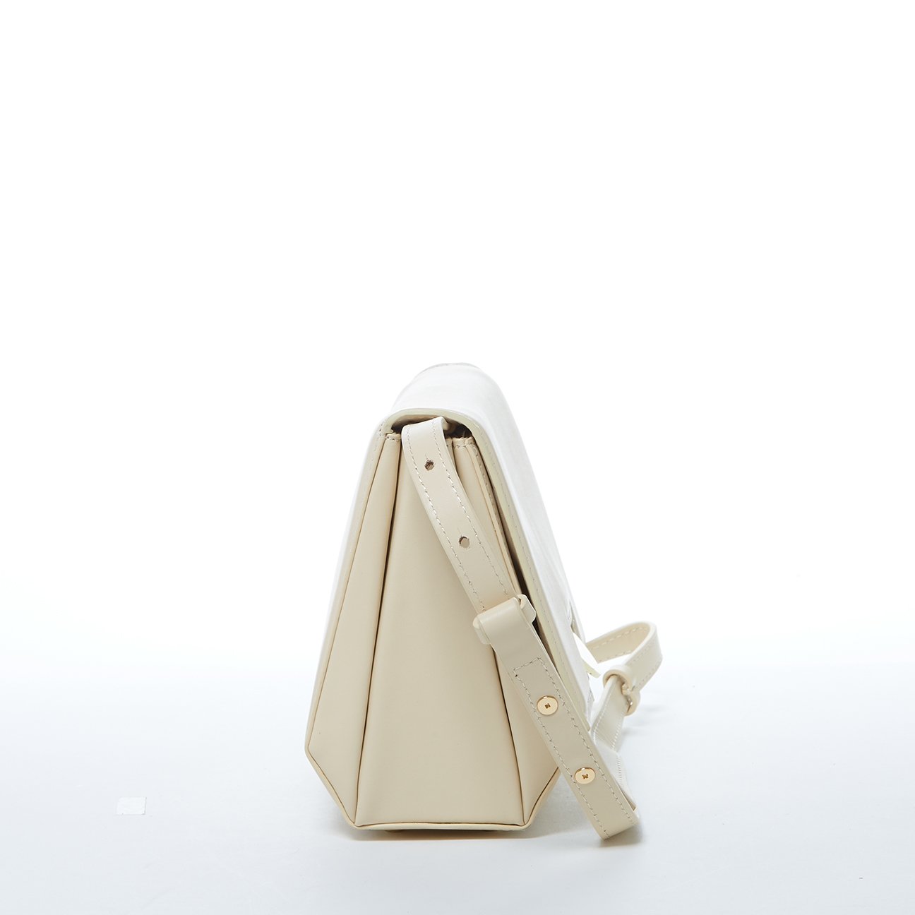  A chic cream leather crossbody bag, small in size, ideal for carrying essentials while maintaining a fashionable look.
