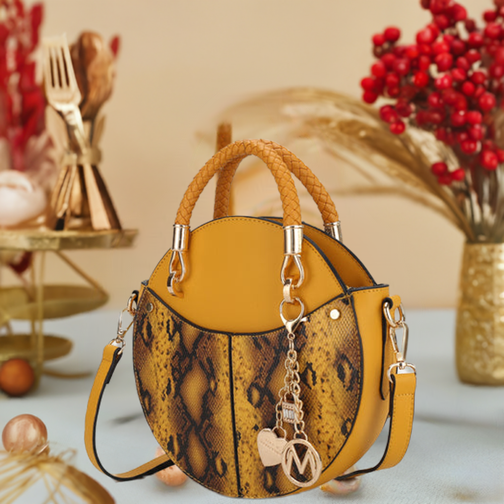 A yellow round bag sitting on the table, featuring a stylish chain strap, showcasing a blend of elegance and modern design.

