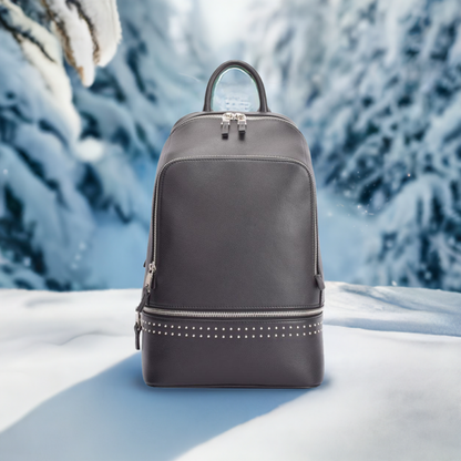 A black backpack featuring studded detailing on the front, showcasing a stylish and edgy design.