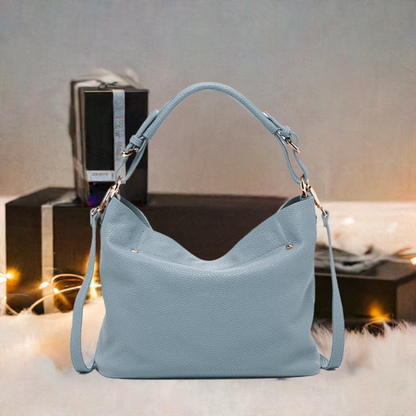 Elegant light blue leather handbag featuring a chic strap, perfect for adding a touch of sophistication to any ensemble.