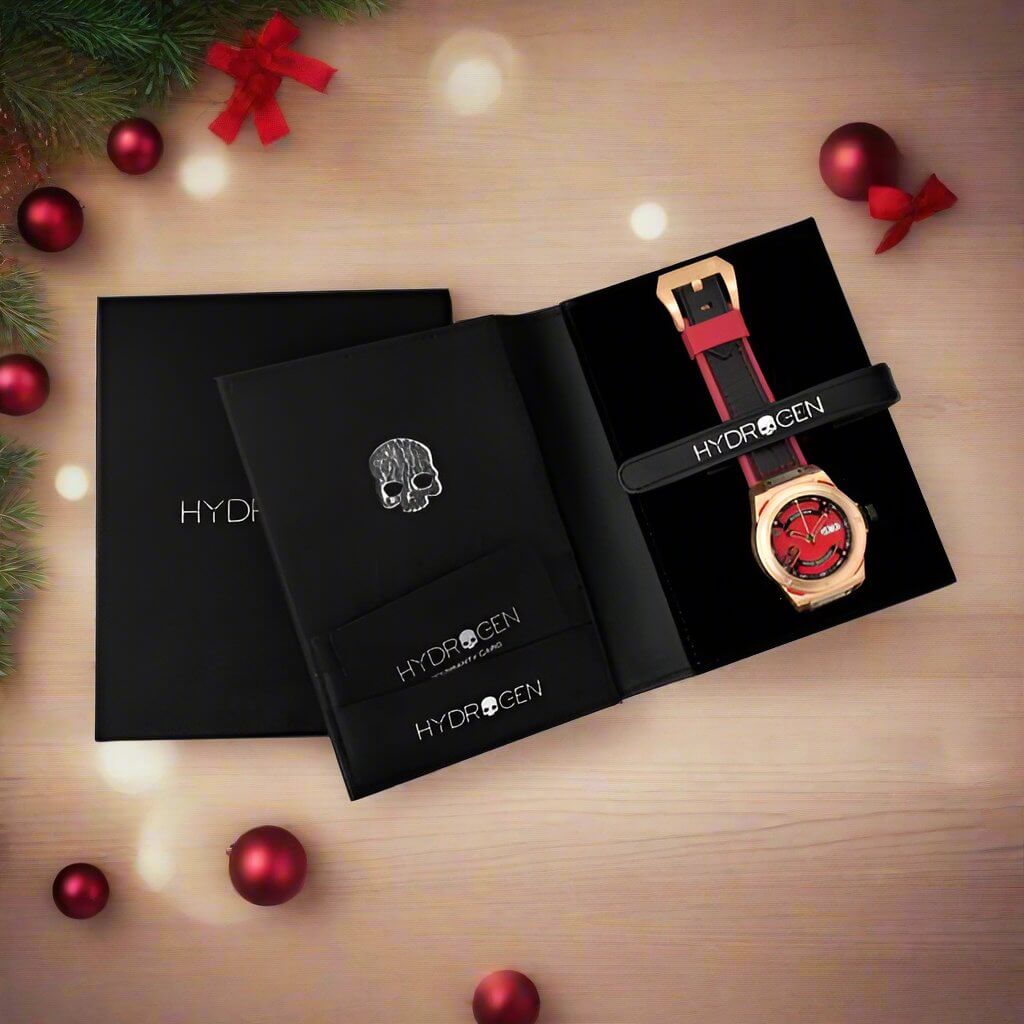 A watch placed beside a red and black box on a table, showcasing a stylish arrangement of accessories.